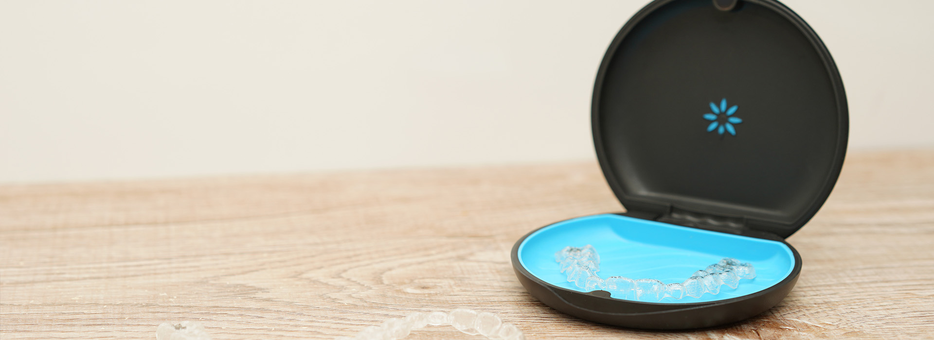 The image shows a smart doorbell with a blue circular base, placed on a flat surface against a plain background.