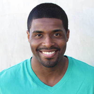 The image shows a man and a woman, both smiling, posing closely together for a photograph.